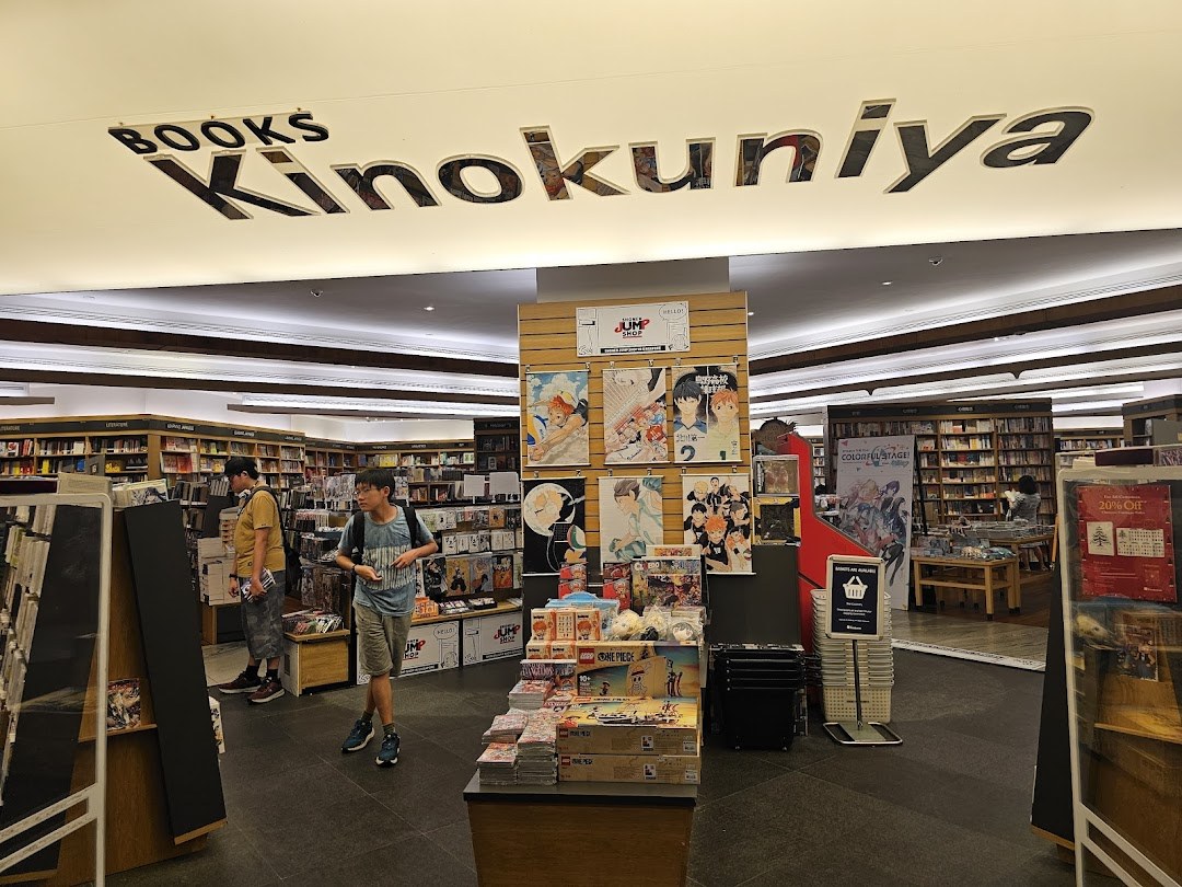 Lorong luas gerai Kinokuniya dengan deretan buku seni (artbook), komik terjemahan, dan majalah desain impor.
