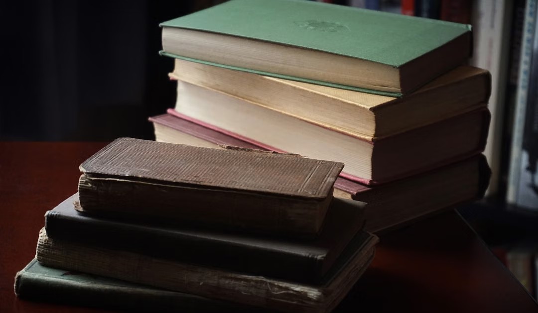 Panduan visual grading buku: perbandingan buku bersegel, berbercak kuning alami, dan bersampul mika rapi.