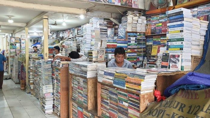 Aktivitas pembeli sedang bertransaksi di kios buku Kwitang di bawah naungan tenda terpal.